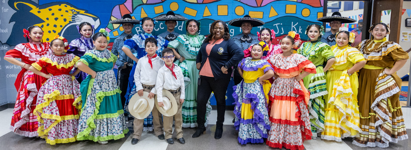 A group of dancers posing with Principal Tatum during the Hispanic Heritage Program.