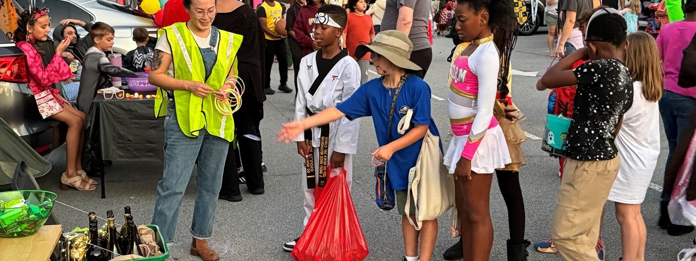 Students dressed up costumes playing games in the parking lot during the PTA Trunk or Treat event.