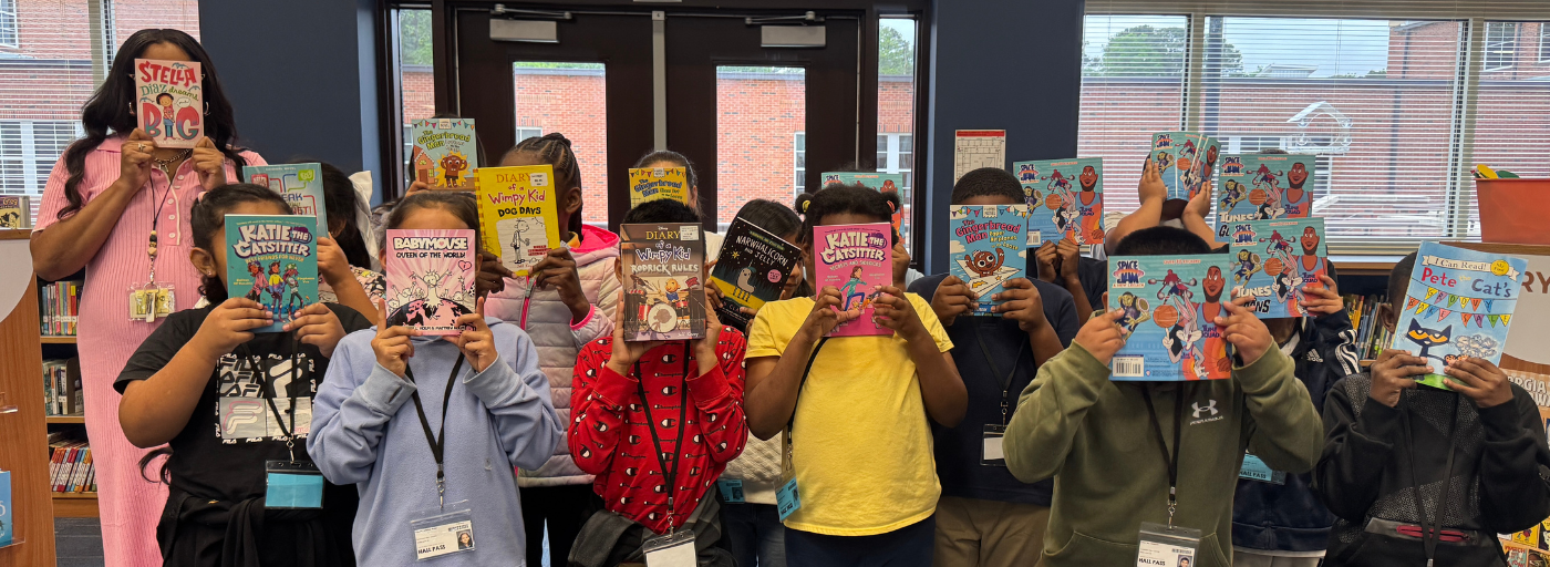 &#34;Free Book&#34; Fair - A group of students holding up a book.
